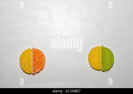 Four Sugar candies. Green, yellow, orange. In a shape of half moon, shaped in a two circles. Stock Photo