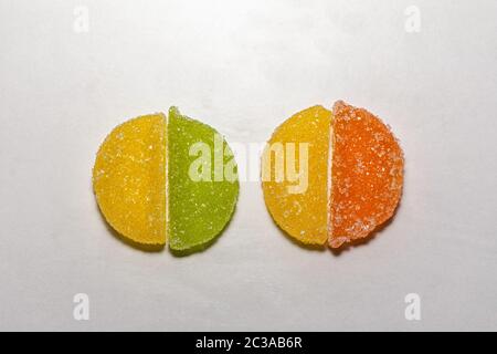 Four Sugar candies. Green, yellow, orange. In a shape of half moon, shaped in a two circles. Stock Photo