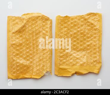fragment of a transparent film with air for transportation of parcels is glued on a yellow sheet of paper, inside of the envelope on a white backgroun Stock Photo
