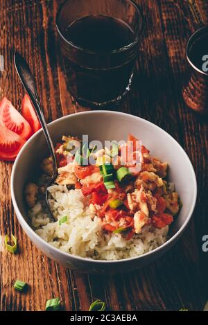 Scrambled eggs with tomatoes and green onion in white bowl. Stock Photo