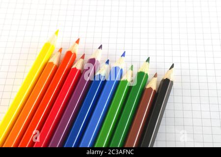 Color pencils on the checked paper of notepad Stock Photo