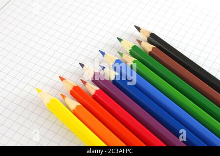 Color pencils on the checked paper of notepad Stock Photo