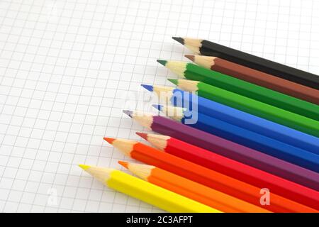 Color pencils on the checked paper of notepad Stock Photo