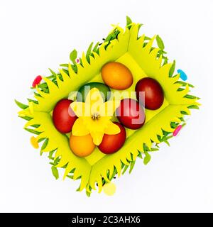 Stash of colourful Easter eggs, wax hand painted and decorated with daffodil in a felt Easter basket on plain, isolated white background, top view Stock Photo