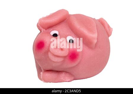 Marzipan sweetness isolated. Close-up of a pink pig made from marzipan as symbol of happiness for the New Year isolated on a white background. Macro p Stock Photo