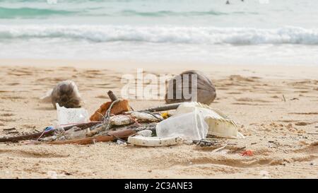 Environmental pollution. Ecological problem. Garbages, plastic, and wastes on the sandy beach of tropical sea. Stock Photo