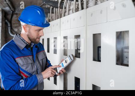 Male Technician Doing Meter Reading Using Tablet Stock Photo