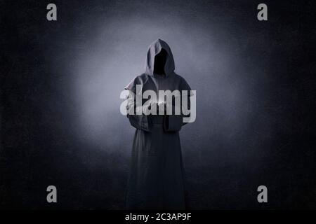 Ghostly figure with light in hands in the dark Stock Photo