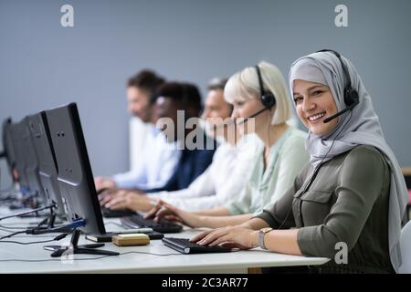 Positive Female Customer Services Agent With Headset Working In A Call Center Stock Photo