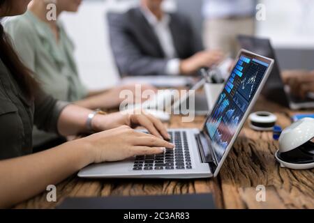 Close-up Of Businesswoman Using Laptop With Graph On Screen In Meeting Stock Photo