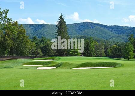 A Beautiful Golf Course with manicured Fairway and Beautiful Mountain Scenery Stock Photo