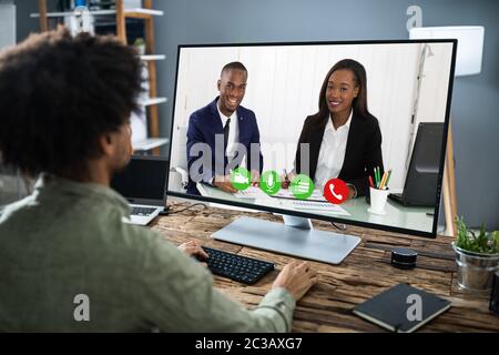 Businessman Sitting At A Desk Watching An Online Presentation On The Computer Stock Photo