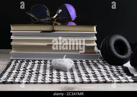 Stack of books and notepads on which are glasses and on the side of headphones. nice background. top views Stock Photo