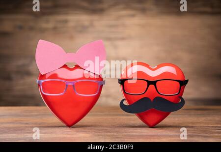 Couple Of Hearts Wearing Glasses On Wooden Table Stock Photo