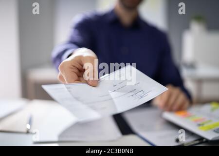 Businessperson Hands Giving Cheque To Other Person Stock Photo