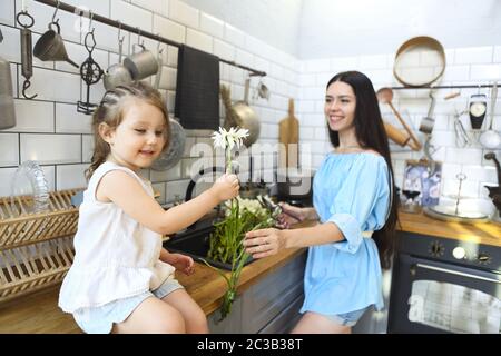Happy girl near mother washing flowers Stock Photo