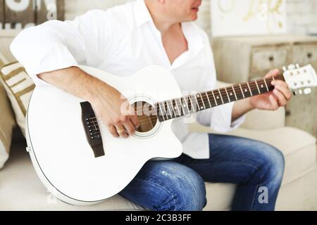 Crop man playing acoustic guitar Stock Photo