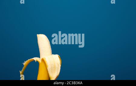 Peeled yellow banana fruit near blue background space for text, healthy concept Stock Photo