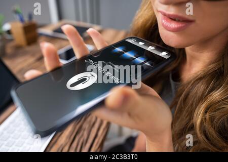 Close-up Of An Woman Using Voice Assistant On Cellphone Stock Photo