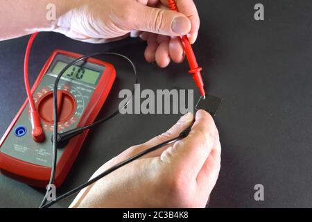Measurement of product electrical parameters using a multimeter. Stock Photo