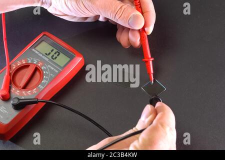 Measurement of product electrical parameters using a multimeter. Stock Photo