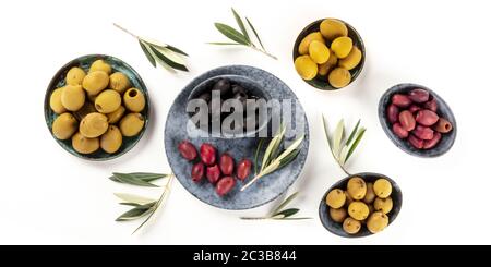 Olives flat lay panorama, top shot on a white background. Black, green and brown olives of different sizes Stock Photo