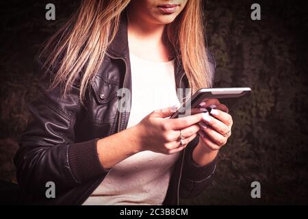 Blonde is busy surfing the Internet with a tablet computer. She sits on a bench in the park and is engaged in self-education. Stock Photo