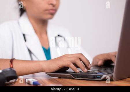 Close-up of doctor hands busy in working on laptop - Online Chat, telehealth, or tele counseling with Patient on computer during coronavirus or covid Stock Photo