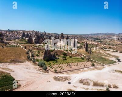 Aerial view of Goreme National Park, Tarihi Milli Parki, Turkey. The typical rock formations of Cappadocia. Tourists on quads Stock Photo