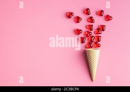 Red hearts and ice cream cone on pink background. Top view. Stock Photo
