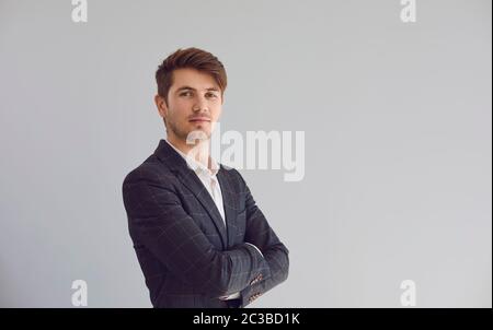 Smiling man crossed his arms in a casual jacket on a gray background. Stock Photo