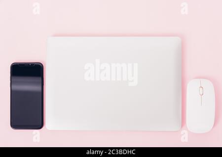Top view of modern technology smart phone mobile and computer laptop close cover on pink background with copy space Stock Photo
