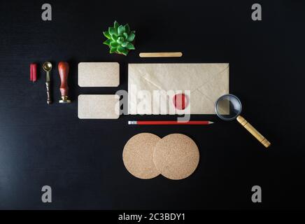 Blank kraft stationery and corporate identity template on black wooden background. Responsive design mockup. Flat lay. Stock Photo