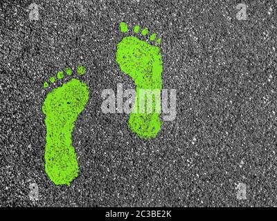 Green footprint signs on an asphalt road for pedestrian. Symbol of walkway. Stock Photo