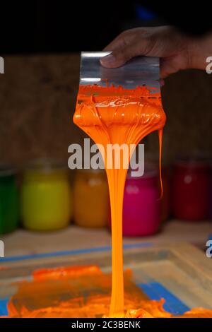 orange color dripping from hand screen printing during printing tee ...