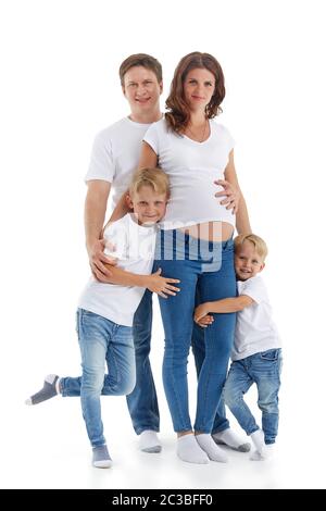 Friendly family. Husband with two sons are smiling and embracing pregnant woman, isolated on a white background.  Happy parents. Pregnant mother and f Stock Photo
