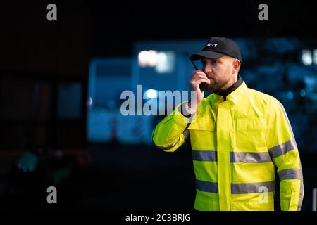 Portrait Of Young Security Guard Using Walkie-talkie Radio Stock Photo