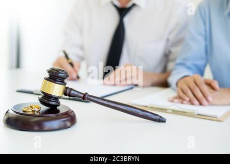 Angry couple arguing telling their problems to Judge gavel deciding on marriage to conclude an agreement on the divorce. They quarrel and argue with e Stock Photo