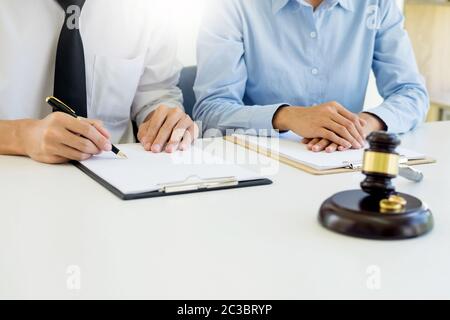 Angry couple arguing telling their problems to Judge gavel deciding on marriage to conclude an agreement on the divorce. They quarrel and argue with e Stock Photo