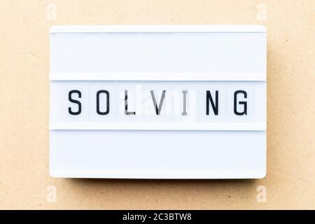 White lightbox with word solving on wood background Stock Photo