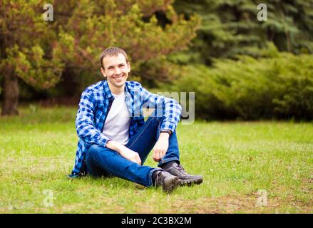 Young man relaxing on grass in park Stock Photo