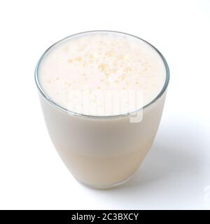 Vanilla milkshake with foam isolated on white. Delicious milk dessert with vanilla in glass isolated on white with clipping path. Stock Photo