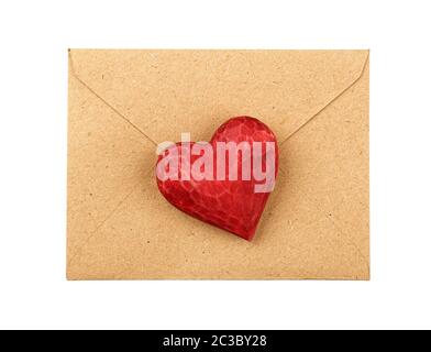 Close up one red painted natural wooden carved heart over brown paper envelope isolated on white background Stock Photo