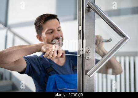 Portrait Young Male Carpenter Repairing Door Lock Stock Photo