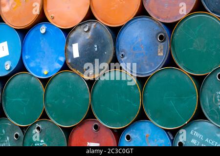 Old chemical barrels. Blue, green, and red oil drum. Steel oil tank. Toxic waste warehouse. Hazard chemical barrel with warning label. Industrial wast Stock Photo