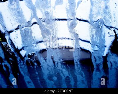 Artistic abstract patterns made on a windscreen whilst car is in a car wash Stock Photo