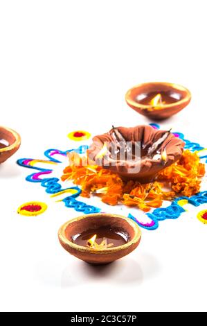 Clay diya lamp lit during diwali festival. Clay Diya on Rangoli. Happy Diwali Greetings Card Design, Indian Hindu Festival of Lights called Diwali. Stock Photo