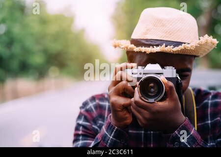 Close up portrait of african traveler and photographer taking pictures with digital camera Stock Photo