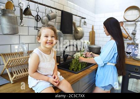 Happy girl near mother washing flowers Stock Photo