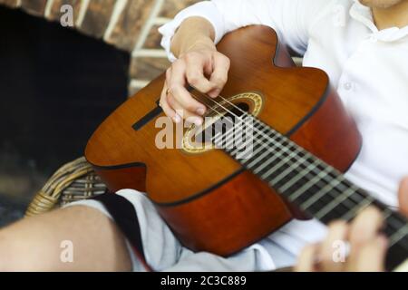 Crop man playing acoustic guitar Stock Photo